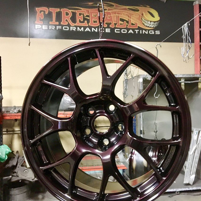 It's a high-gloss black with a red cherry flake. If you turn the wheel sideways or in the shade it looks black!
